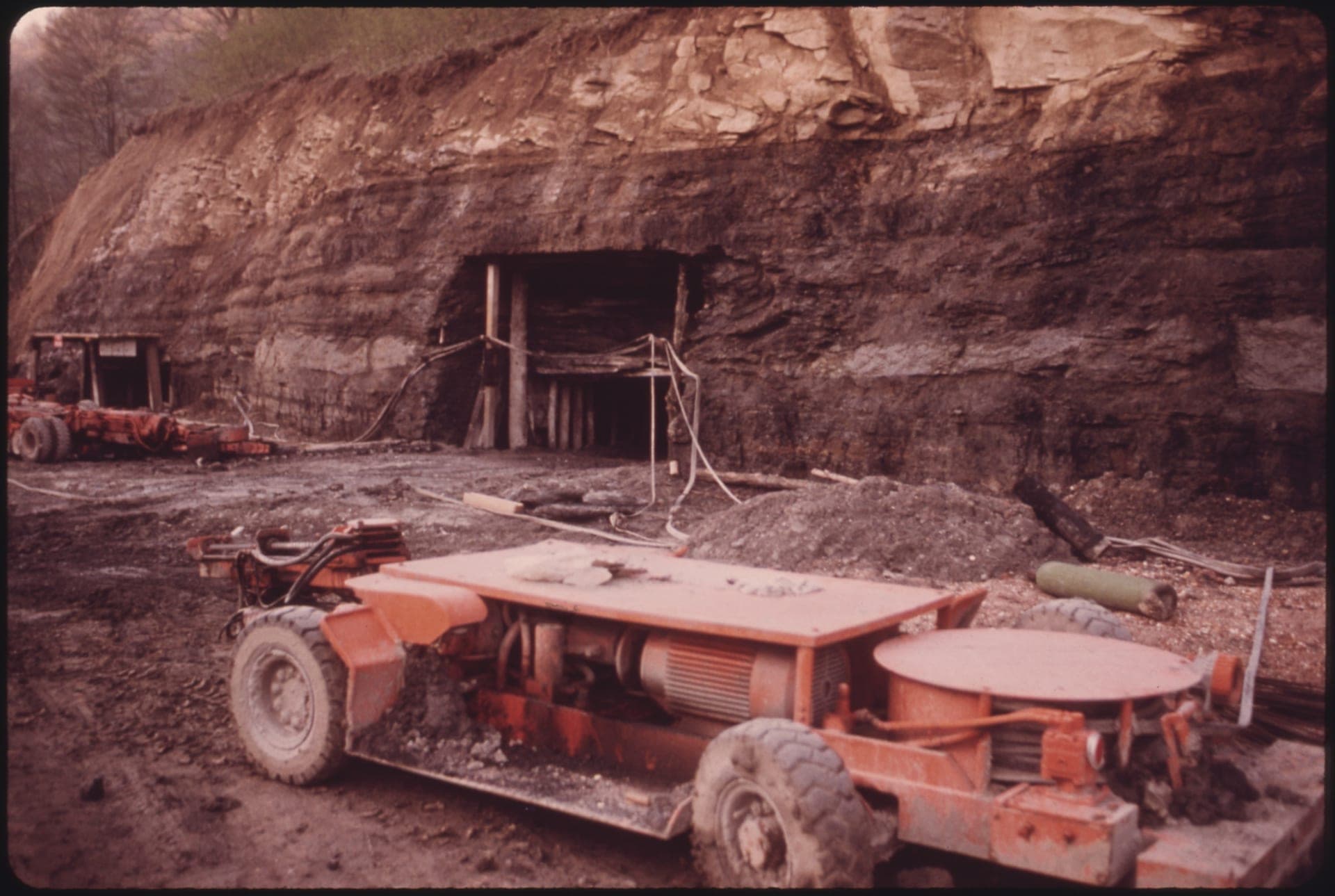 Underground coal mine portal opening with mining equipment in the foreground, West Virginia